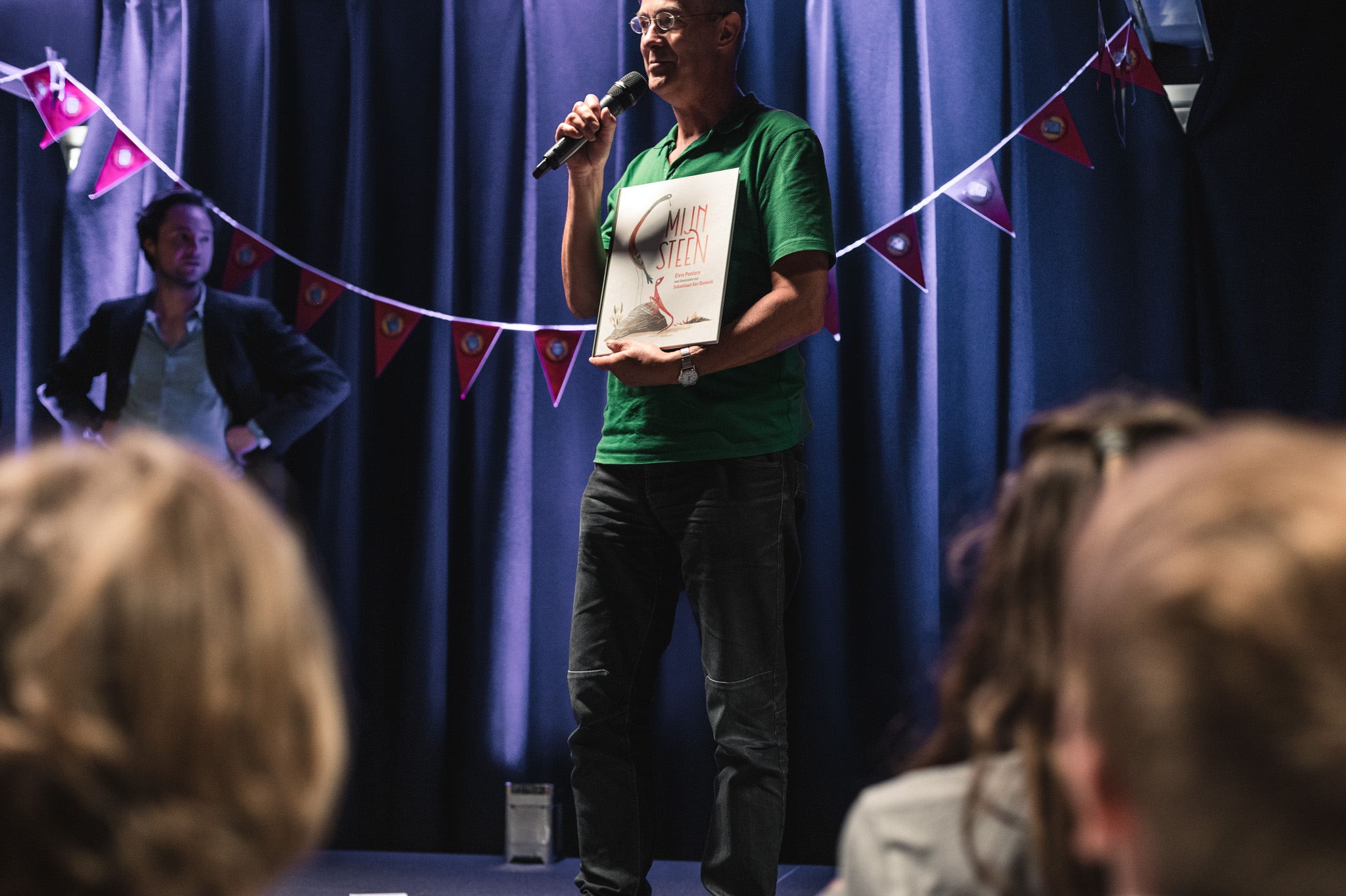 jeugdauteur elvis peeters leest voor op het podium tijdens een slotfeest van de kinder- en jeugdjury