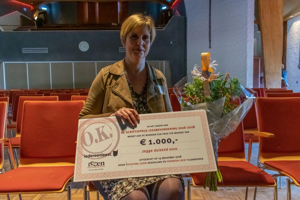 Winnaar van de Scriptieprijs Leesbevordering met bloemen en cheque